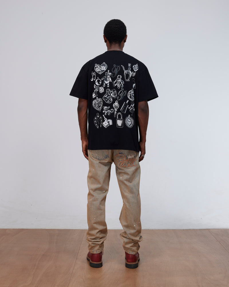 Back view of a model wearing the black Patta Charm T-Shirt with charms artwork.