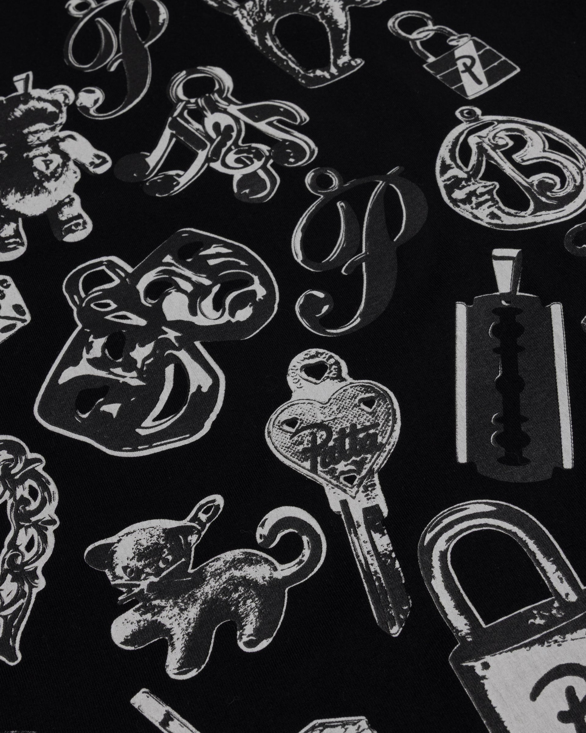 Close-up of the charms graphic print on the black Patta Charm T-Shirt.