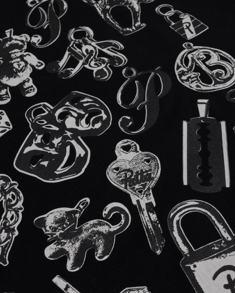 Close-up of the charms graphic print on the black Patta Charm T-Shirt.