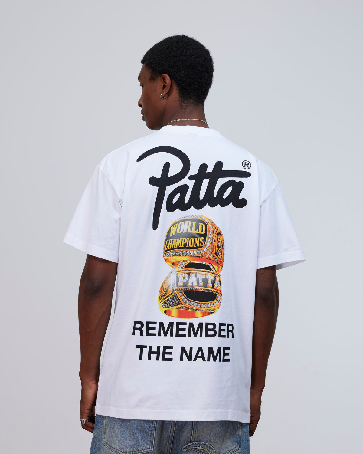 Back view of a model wearing the white Patta Championship T-Shirt with championship rings graphic.