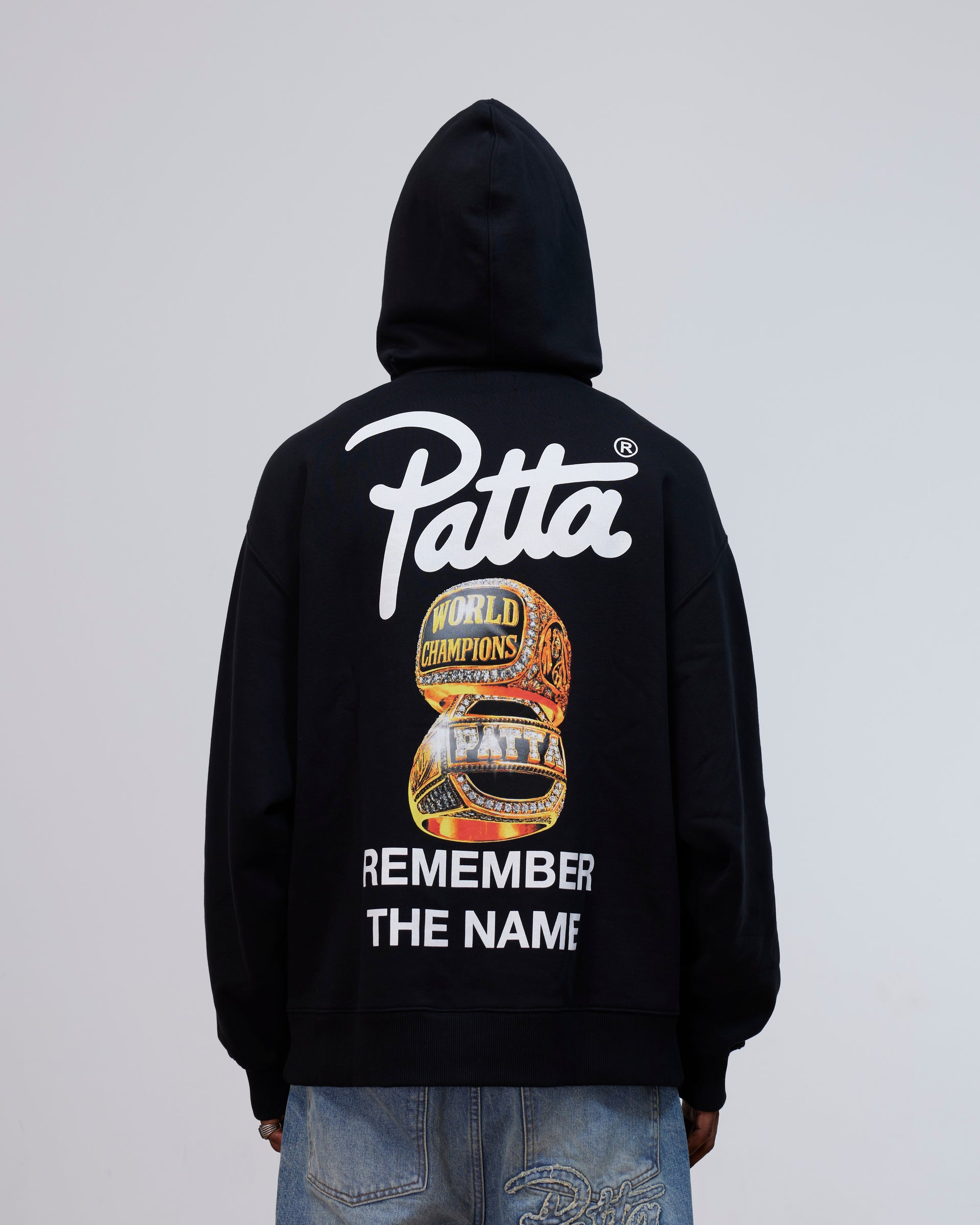 Back view of the Patta Kids Championship Hooded Sweater in black with rings graphic and logo print.