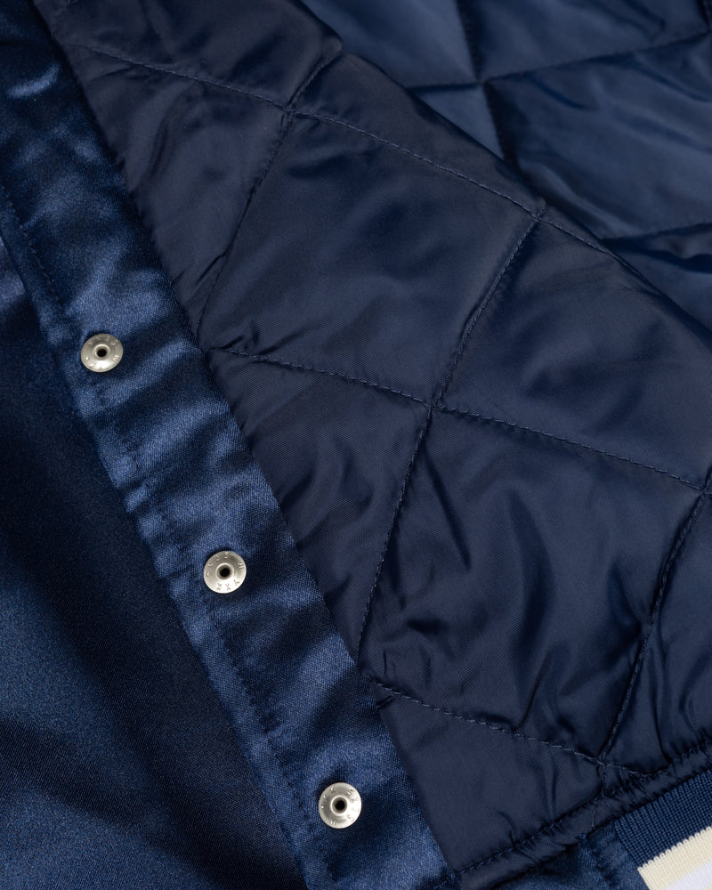 Close-up of the quilted lining and snap buttons on the Patta Kids Satin Bomber Jacket in Black Iris.